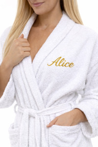 Žena v bílém froté županu se zlatou výšivkou Alice