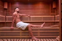 Muž v bílém saunovém kiltu relaxující v sauně