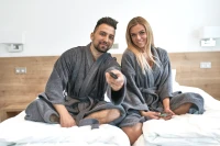 Dámský a pánský froté župan střihu kimono tmavě šedý - pár sedící na posteli