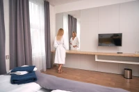 Dámský župan froté bílý kimono - žena v hotelovém pokoji zdálky