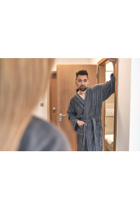 Muž a žena v šedých županech střihu kimono v hotelovém pokoji