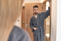 Muž a žena v šedých županech střihu kimono v hotelovém pokoji