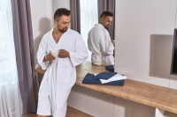 Pánský froté župan střihu kimono bílý - muž v hotelovém pokoji
