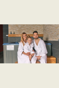 Rodina v bílých froté županech sedící ve wellness